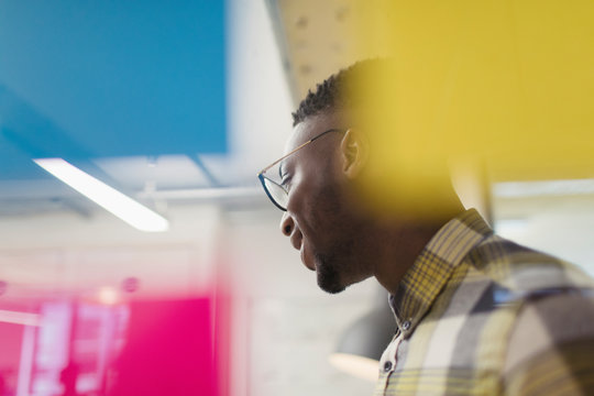 Smiling creative businessman behind adhesive notes