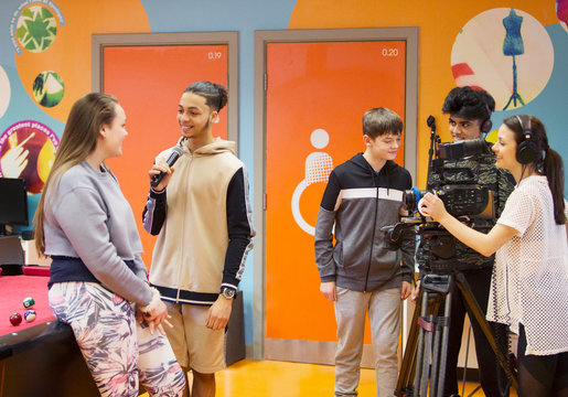 Teenagers with video camera and microphone vlogging