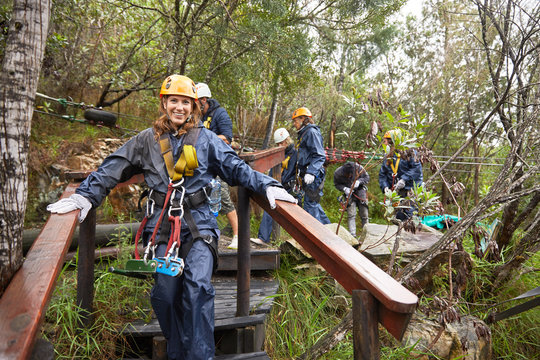 Portrait smiling woman preparing to zip line - Powered by Adobe