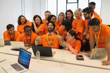 Portrait confident hackers coding for charity at hackathon
