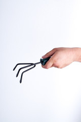 Garden fork rake close-up. Man's holding gardening tool. White isolated background.