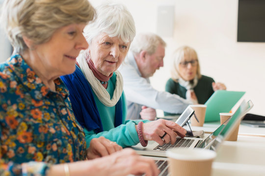 Senior businesswomen using laptops in conference room meeting