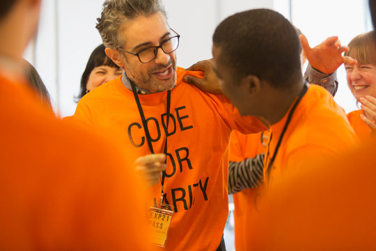 Happy hackers hugging, coding for charity at hackathon