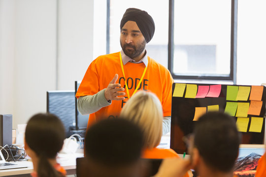Hacker in turban leading meeting, coding for charity at hackathon