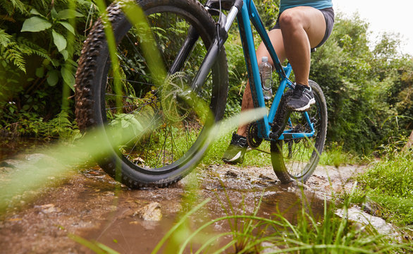 Woman mountain biking on muddy trail