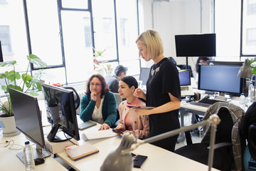 Businesswomen working at computer in open plan office