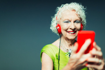 Carefree senior woman with headphones mp3 player listening to music