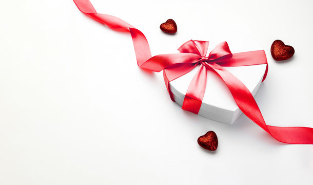 Valentines day background. White gift box with bow and red ribbon heart, photo template, background. Top View.