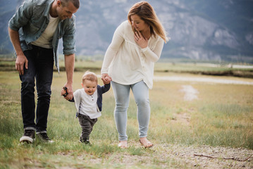 Parents walking with baby son in rural field
