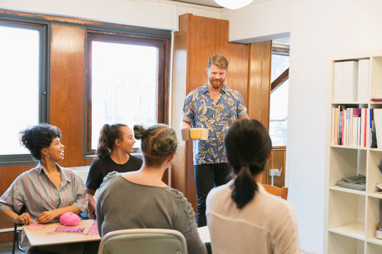 Creative businessman serving coffee and tea to colleagues