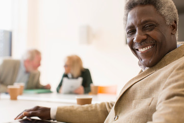 Portrait smiling, confident senior businessman in conference room meeting