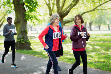 Active senior women friends power walking sports race in park