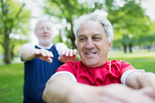 Active Senior Men Exercising In Park