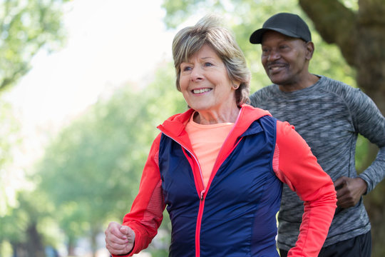 Smiling active senior woman power walking in park