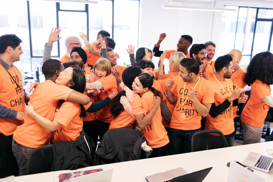 Enthusiastic hackers celebrating, coding for charity at hackathon