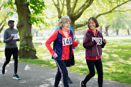 Active senior women friends power walking sports race in park
