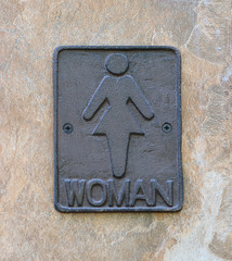 Female toilet sign on brick wall
