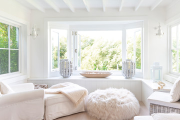 White home showcase sitting area with windows open to garden