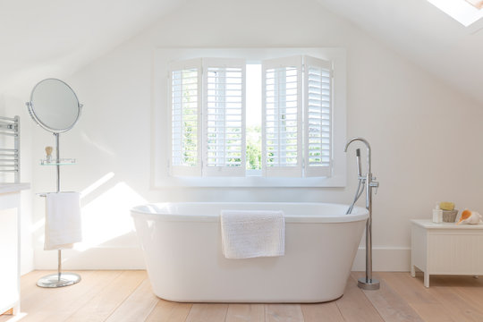 Tranquil white home showcase bathroom with soaking tub