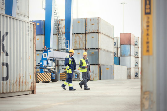 Dock workers walking and talking at shipyard