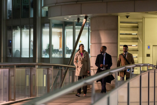 Business people walking on urban pedestrian bridge at night