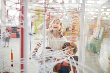 Teacher and students looking at exhibit in science center