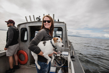 Portrait smiling woman with dog on fishing boat