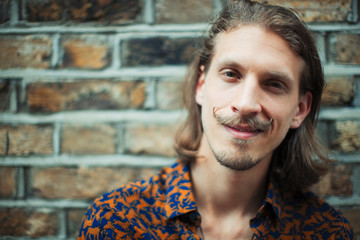 Portrait smiling, confident young male hipster with mustache