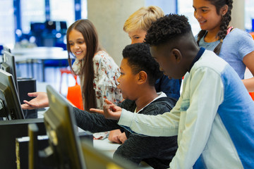Junior high students using computer in library