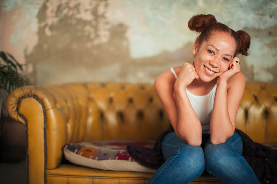 Portrait smiling, confident young woman sitting on sofa