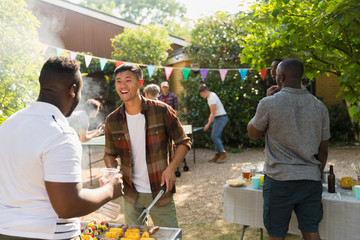 Male friends enjoying backyard summer barbecue