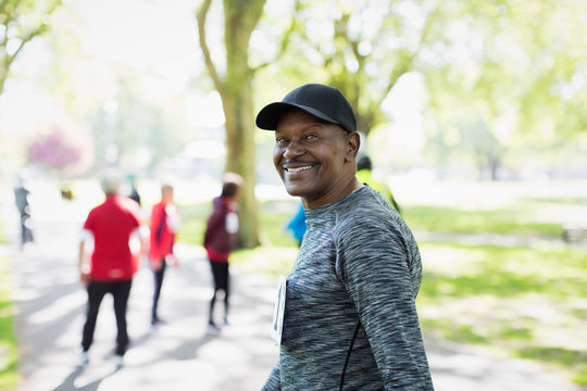 Portrait confident, happy senior man walking sports race in park
