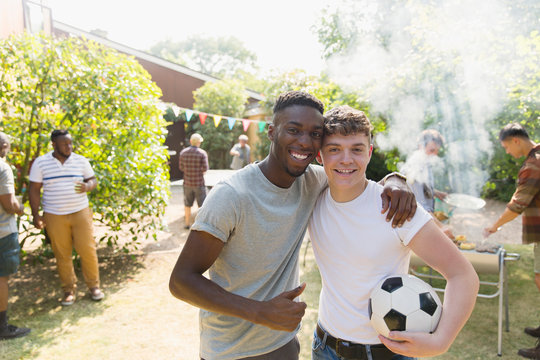Fototapeta Portrait confident young men soccer ball enjoying backyard barbecue