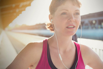 Close up confident young female runner with headphones