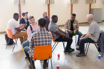 Men talking in group therapy in community center
