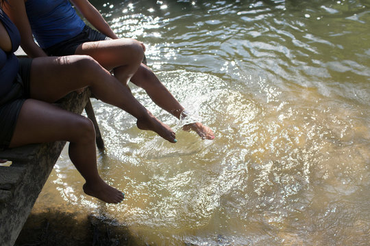 Family splashing legs in sunny river