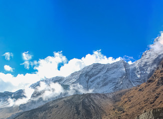 Top of the hill, covered with snow and white clouds