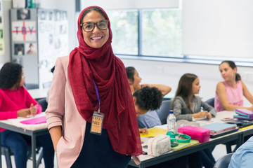 Portrait smiling, confident female teacher wearing hijab in classroom