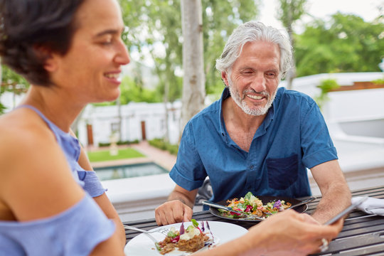 Mature couple dining at patio table