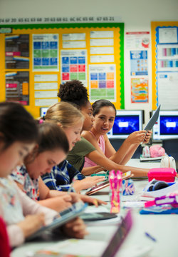 Junior high school girl student using digital tablets at desk in classroom