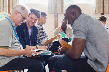Men reading paperwork in group therapy in community center