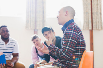 Men talking and listening in group therapy