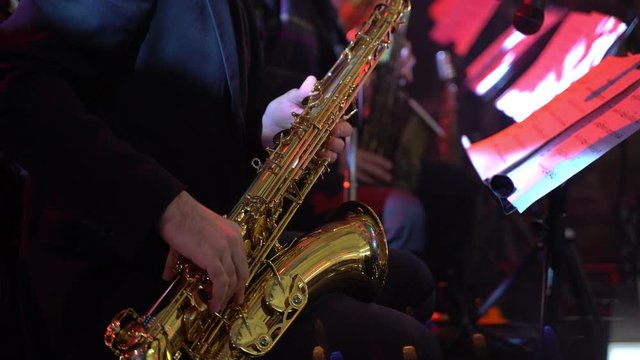 Saxophonist in dinner jacket play on golden saxophone. Live performance. Jazz music.