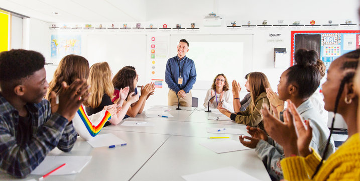High school students clapping for teacher in debate class
