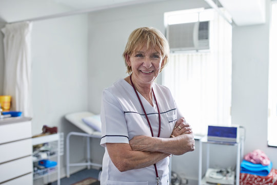 Portrait confident senior female nurse in clinic