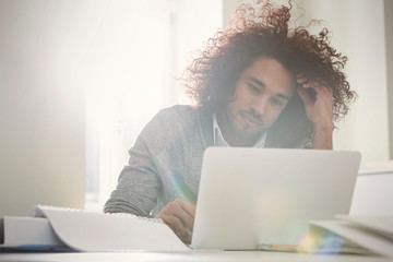 Focused young man working at laptop