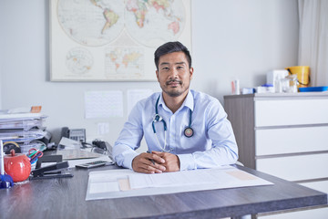 Portrait confident male doctor working in clinic doctors office