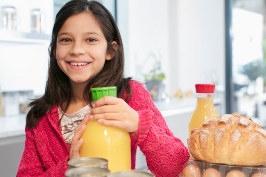 Portrait smiling girl with orange juice in kitchen