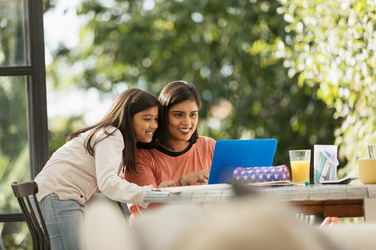 Mother and daughter using laptop