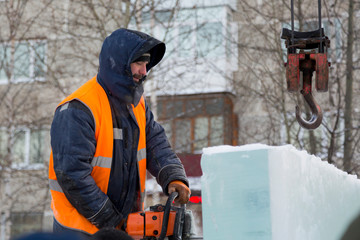 Worker cuts ice panel with gasoline saw